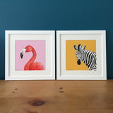 Flamingo and zebra illustration prints framed and side by side.